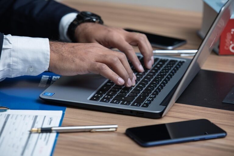 Lawyer typing on a laptop at a desk while managing legal work and digital tasks